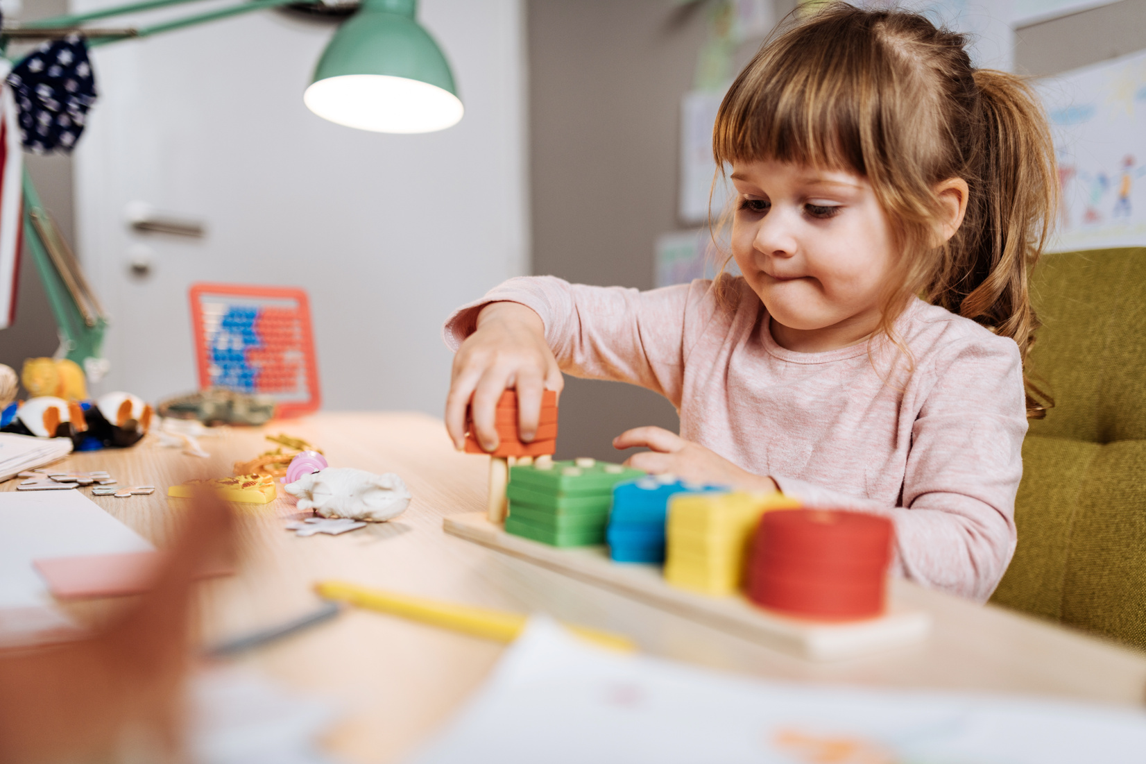 Three year old girl playing mind games at home
